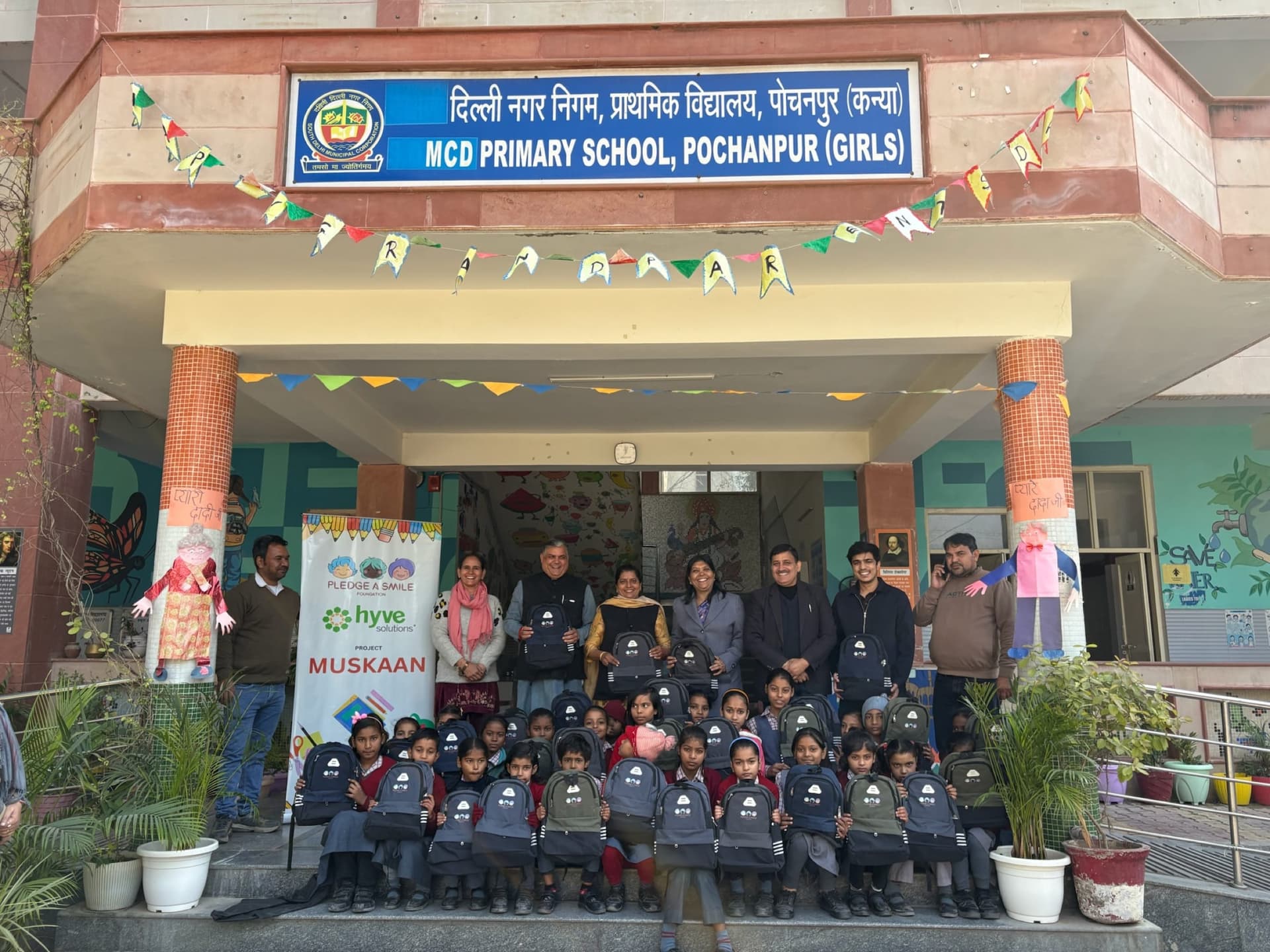 Kids and teachers at a decorated school entrance during a Muskaan drive