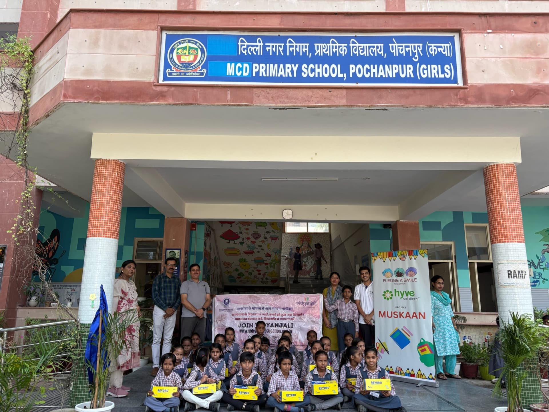 School-wide stationery distribution beneath MCD Primary School facade