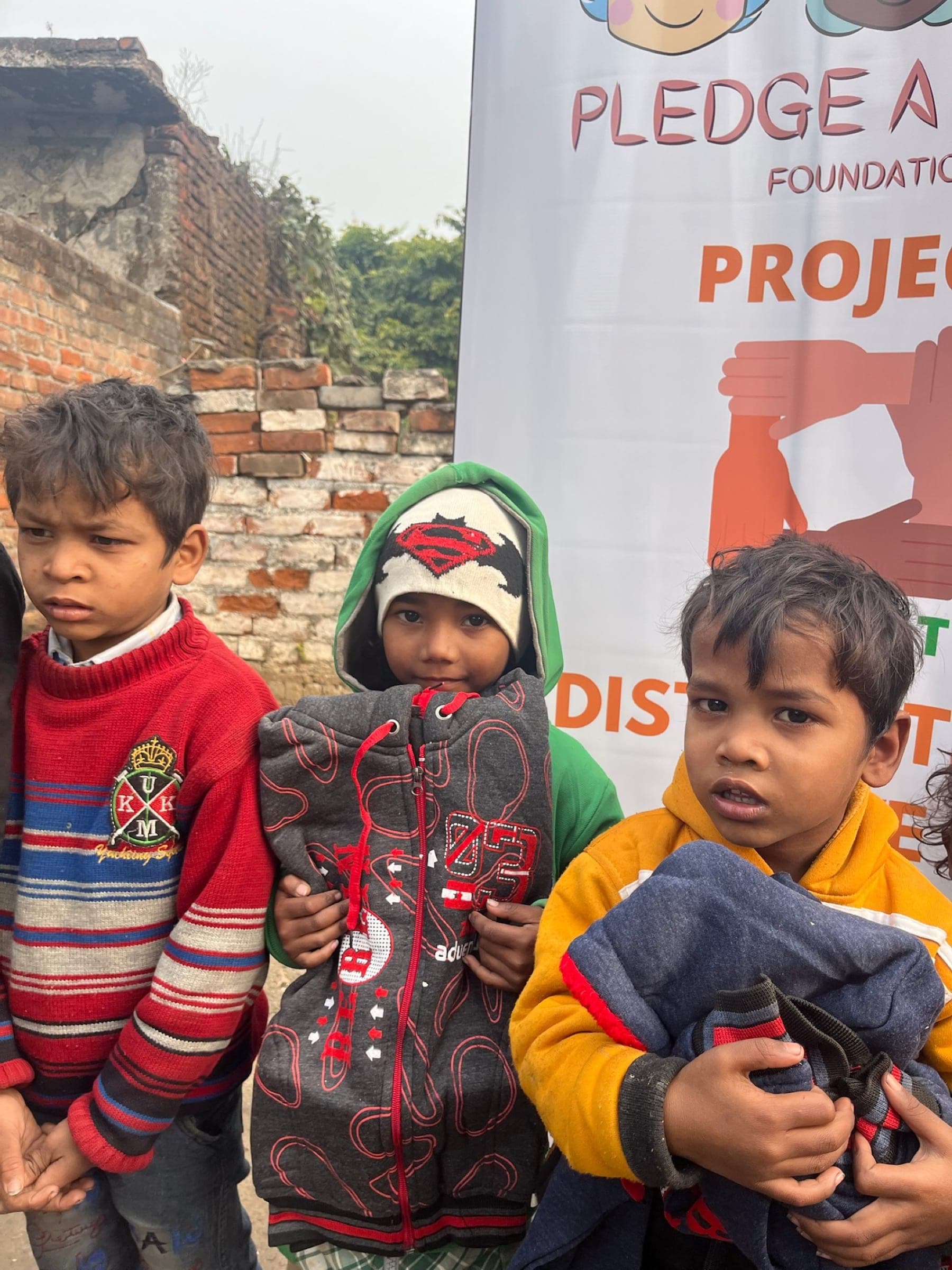 Three young boys clutch their new winter jackets