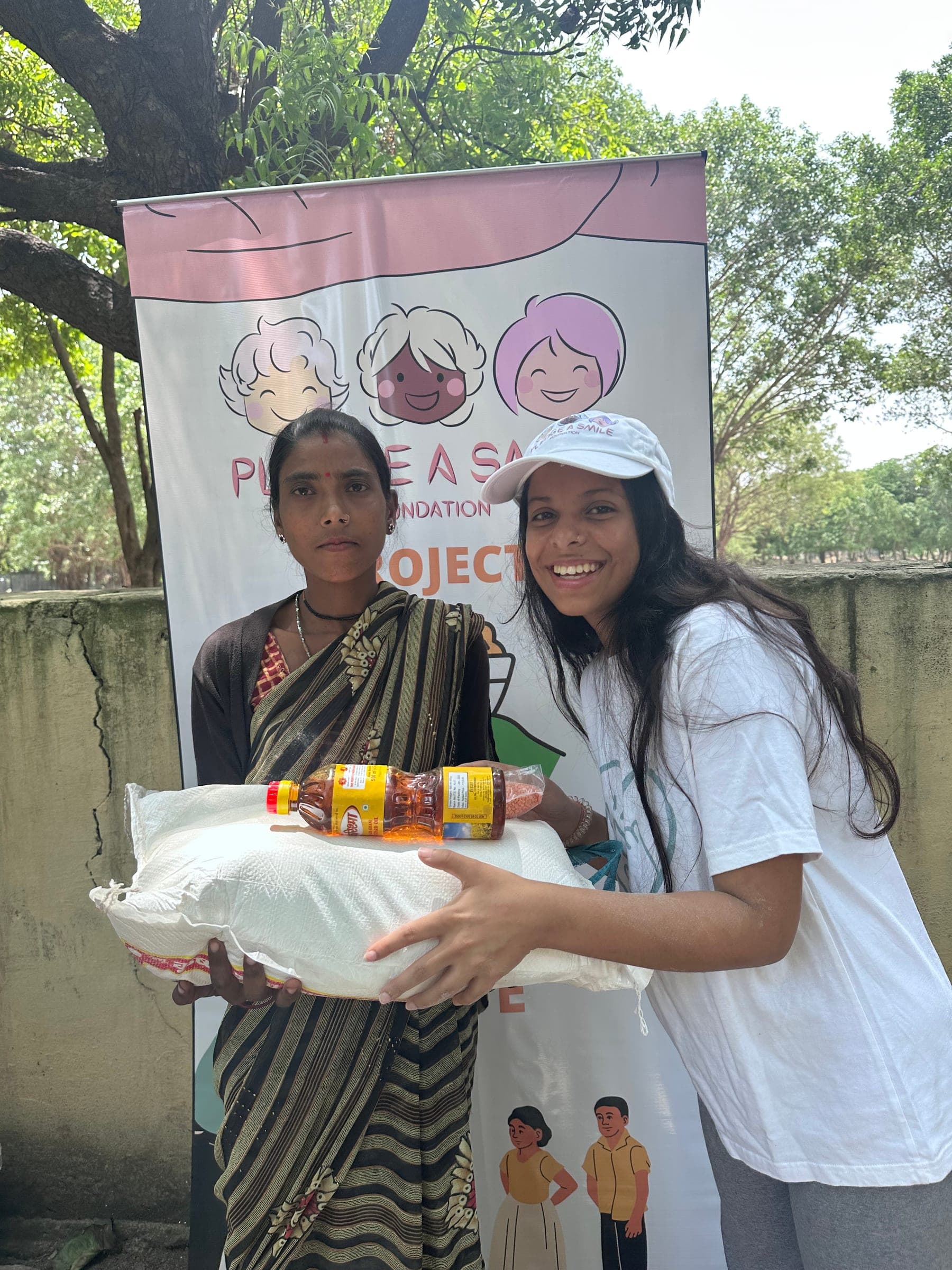 A capped Pledge A Smile volunteer shares a warm moment with an elderly woman receiving her grain sack.